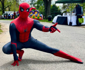 Photo of a costumed Spiderman posing with a pointing finger. 